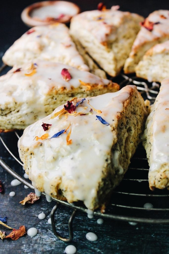 side view of earl grey scones with vanilla bean icing on a circular cooking rack