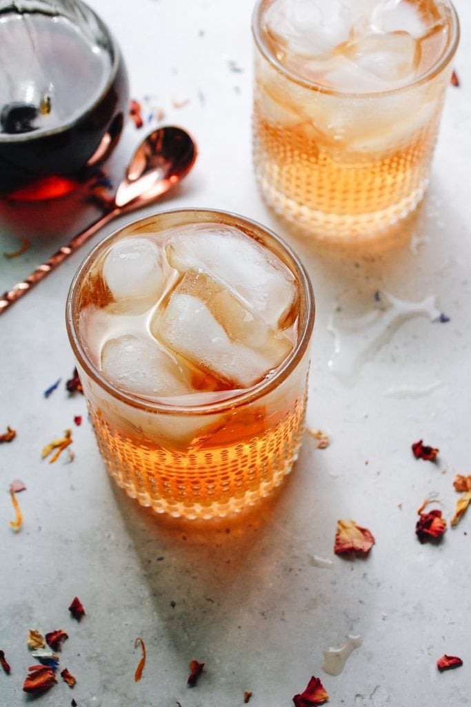 homemade soda in clear glasses surrounded by dried edible flowers