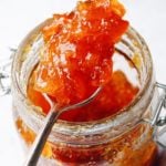 spoon with kumquat jam on a spoon resting on the jar of jam