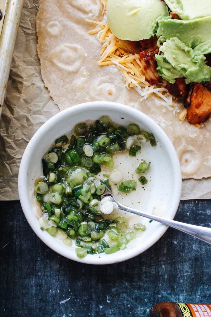 marinated green onions in a small white dish