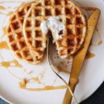 oat flour waffles on a beige plate with butter and syrup