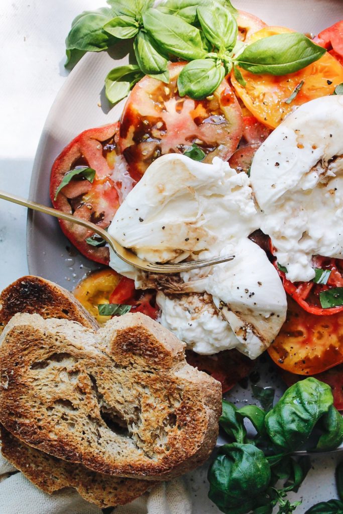caprese burrata on a gray plate with garlic toasts
