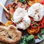 caprese salad with burrata cheese on a gray plate