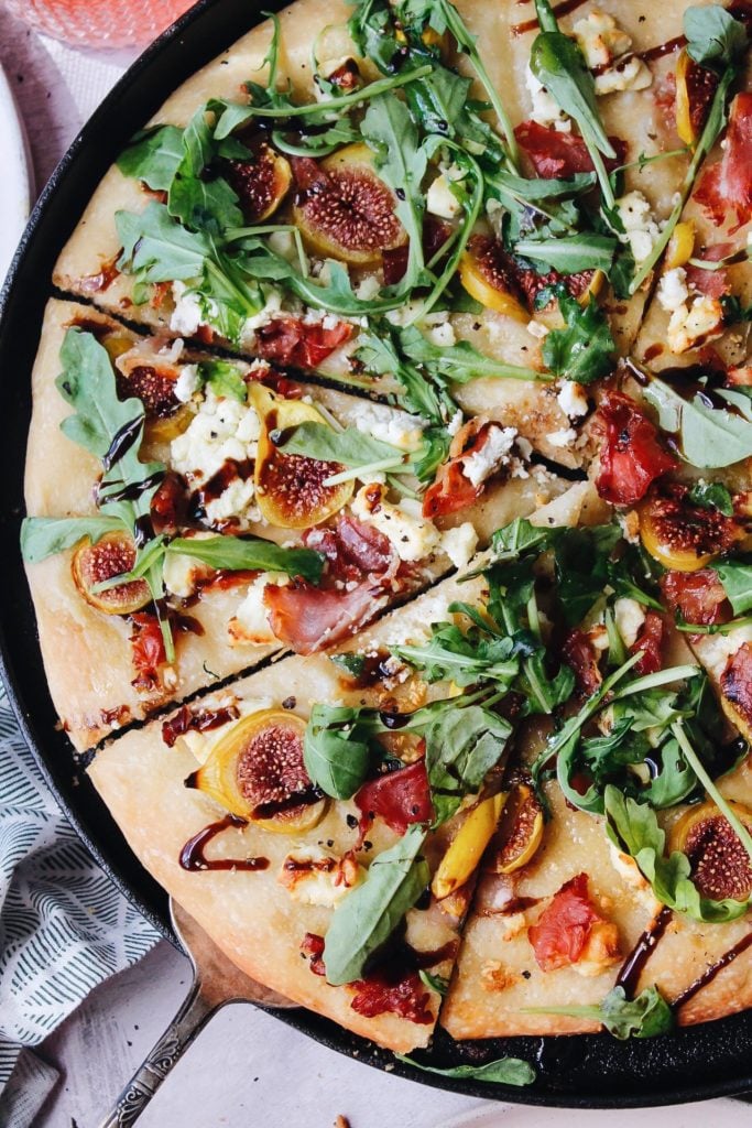 close up of fig and prosciutto pizza in a cast iron pan