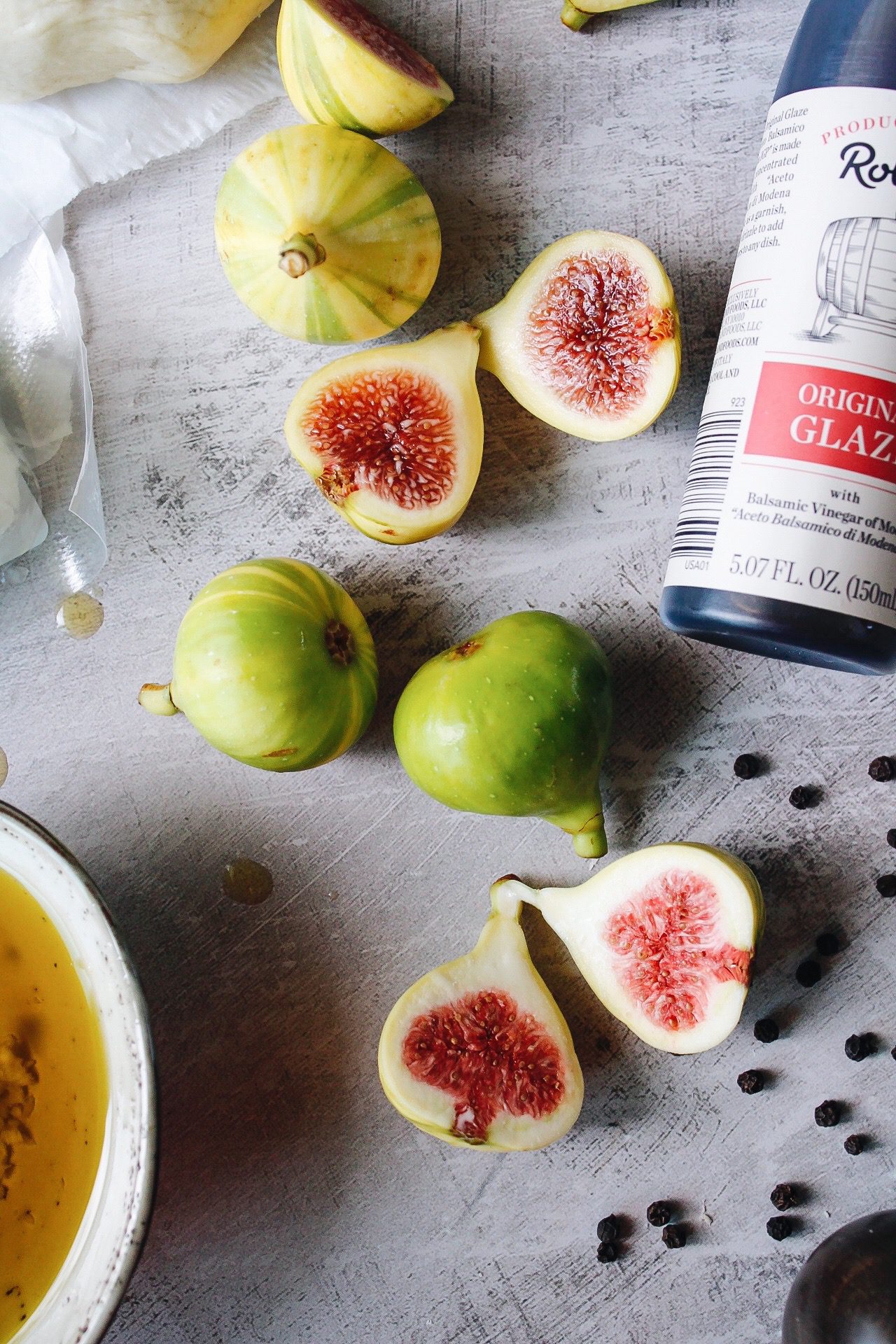 tiger striped figs cut in half on a gray background