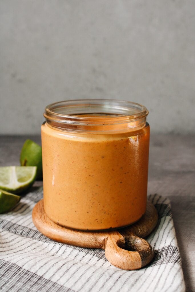 chipotle southwest sauce in a glass jar on a wooden coaster