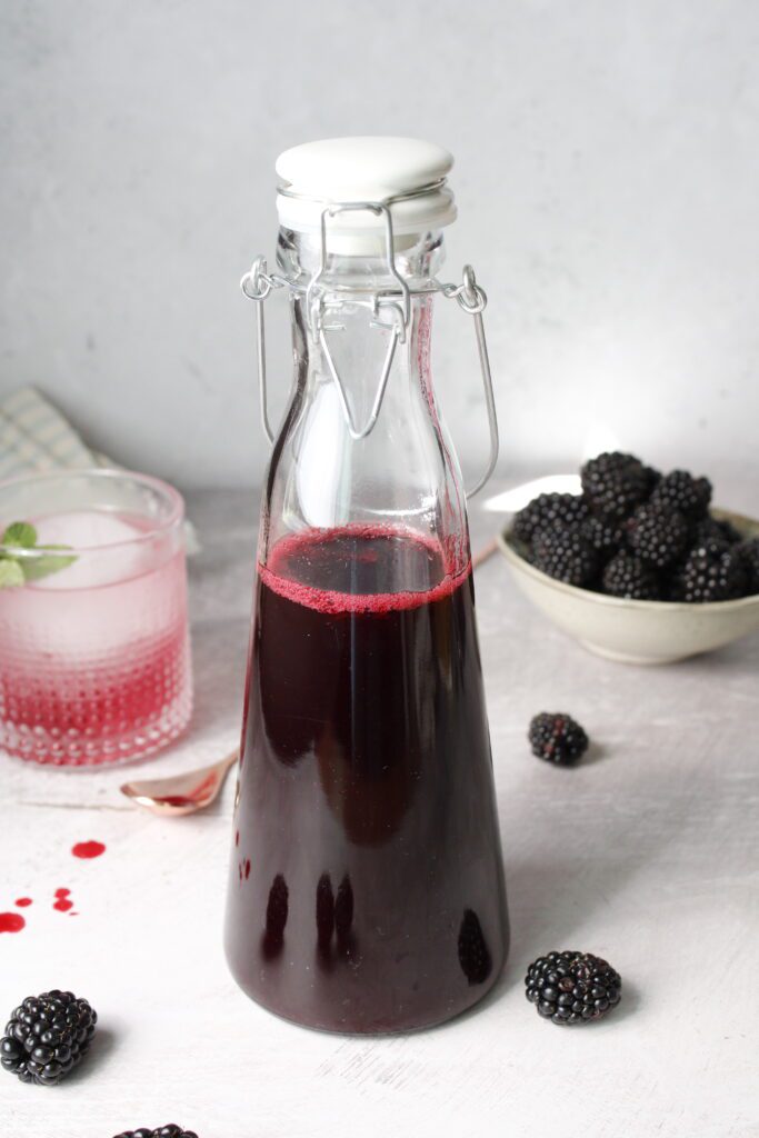 blackberry simple syrup in a tall glass bottle