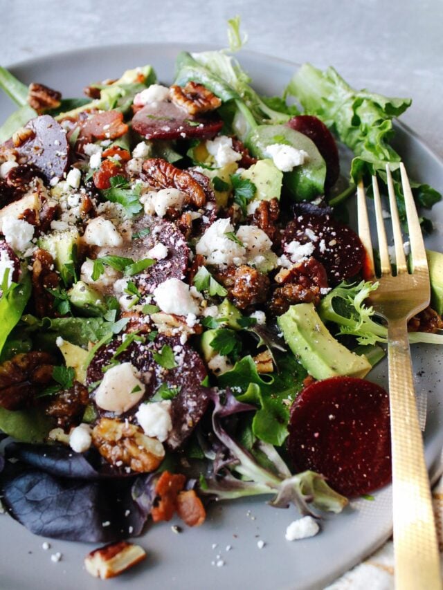 beet and avocado salad on a gray plate with a gold fork