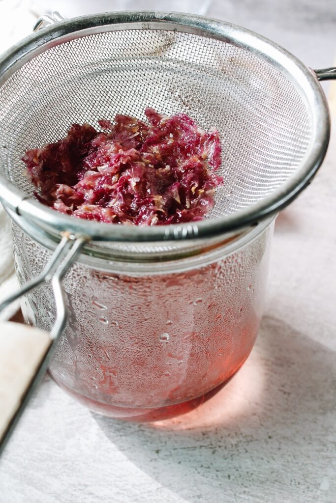 straining petals through a mesh sieve