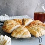 honey scones on a wire baking rack with butter in the foreground and honey in the background