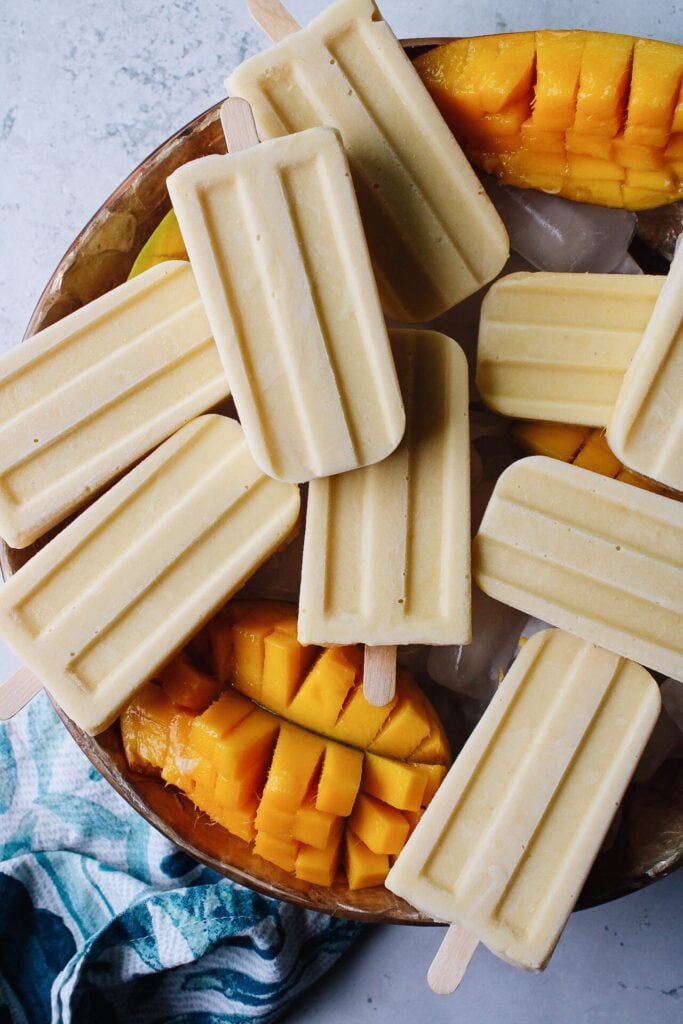 mango popsicles on a bowl of ice