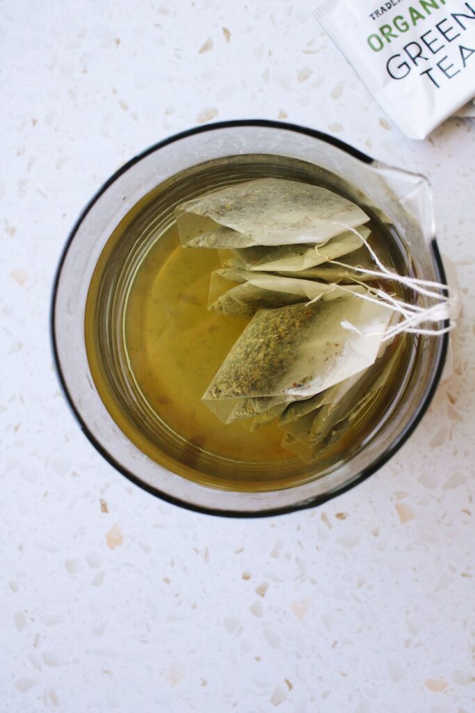 green tea steeping in a clear glass container