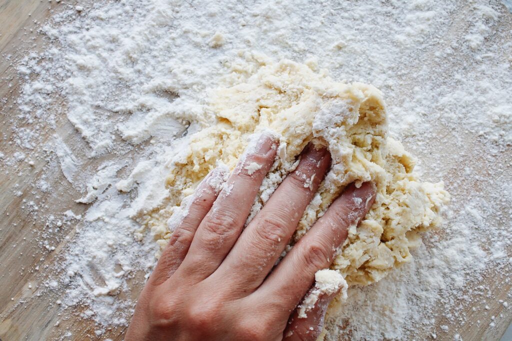honey scone dough being kneaded by hand
