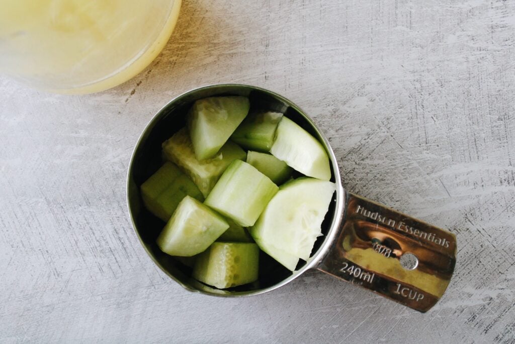 chopped cucumber in a measuring cup