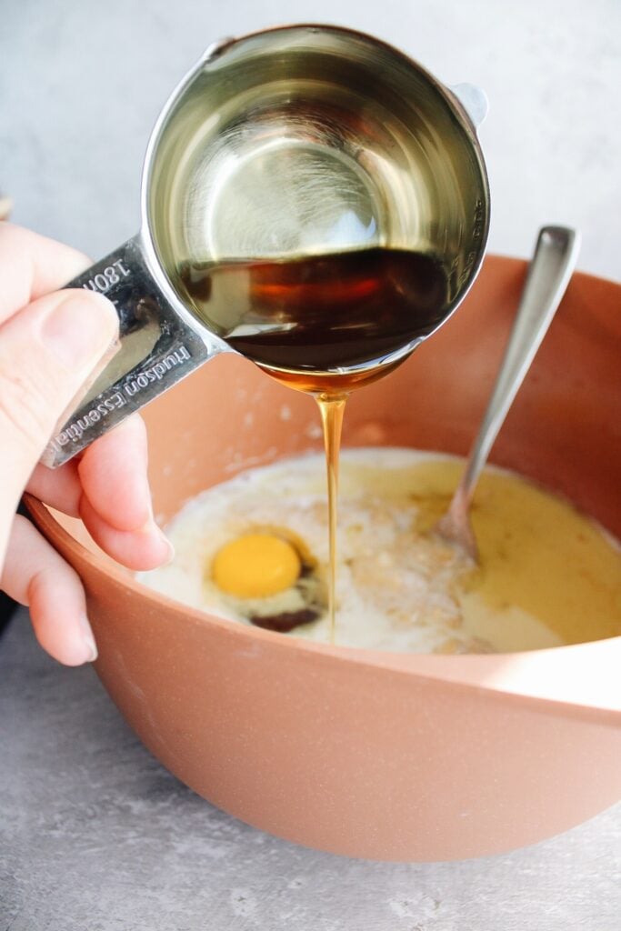 honey being added to banana bread with other wet ingredients