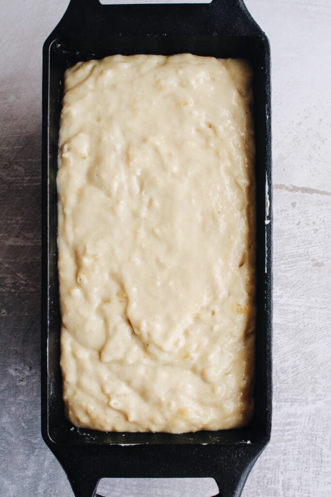 honey banana bread batter in a cast iron loaf pan before baking