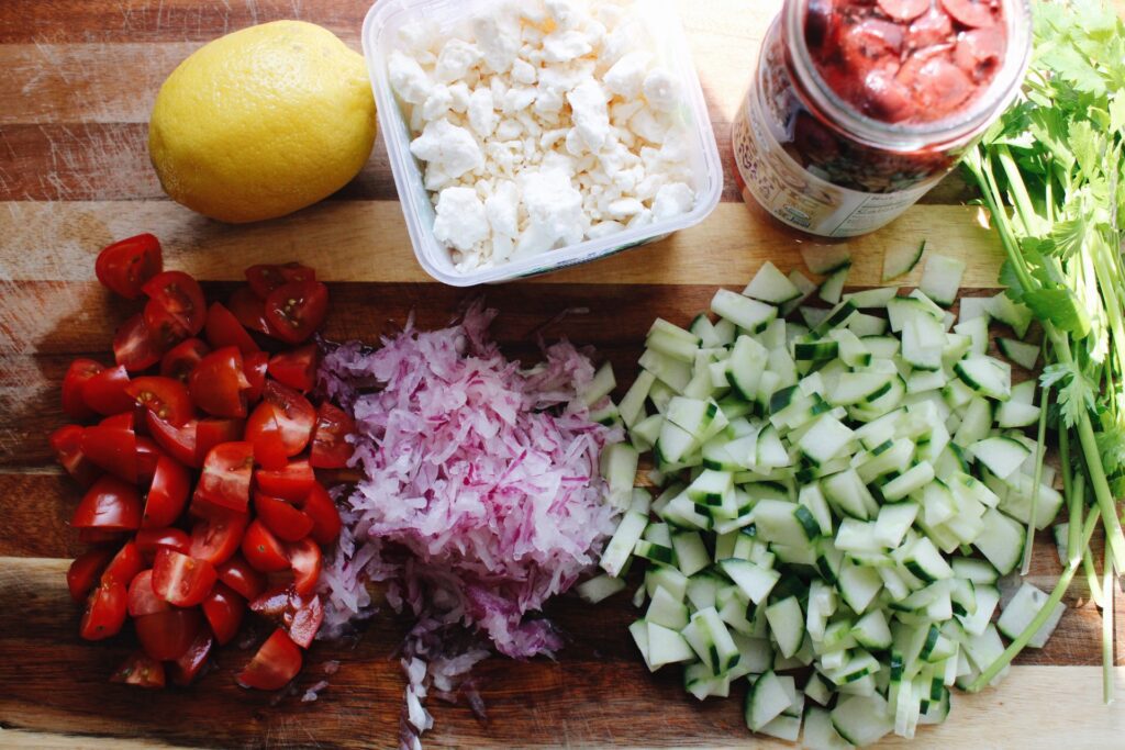 mediterranean pasta salad ingredients on a cutting board