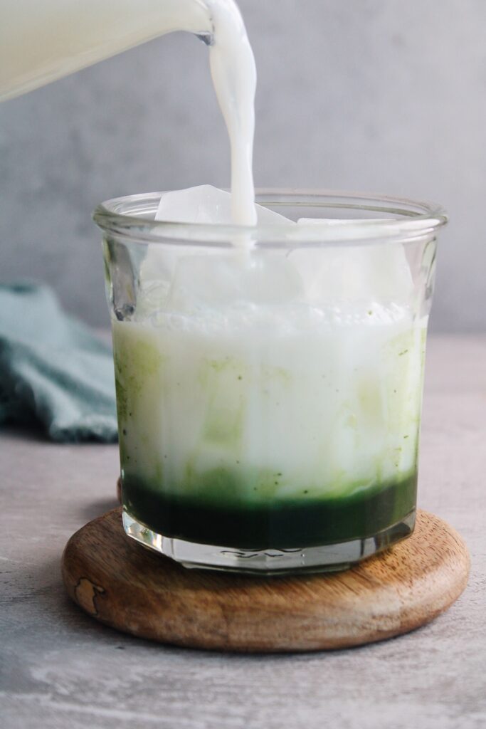 milk being added to matcha and lavender syrup
