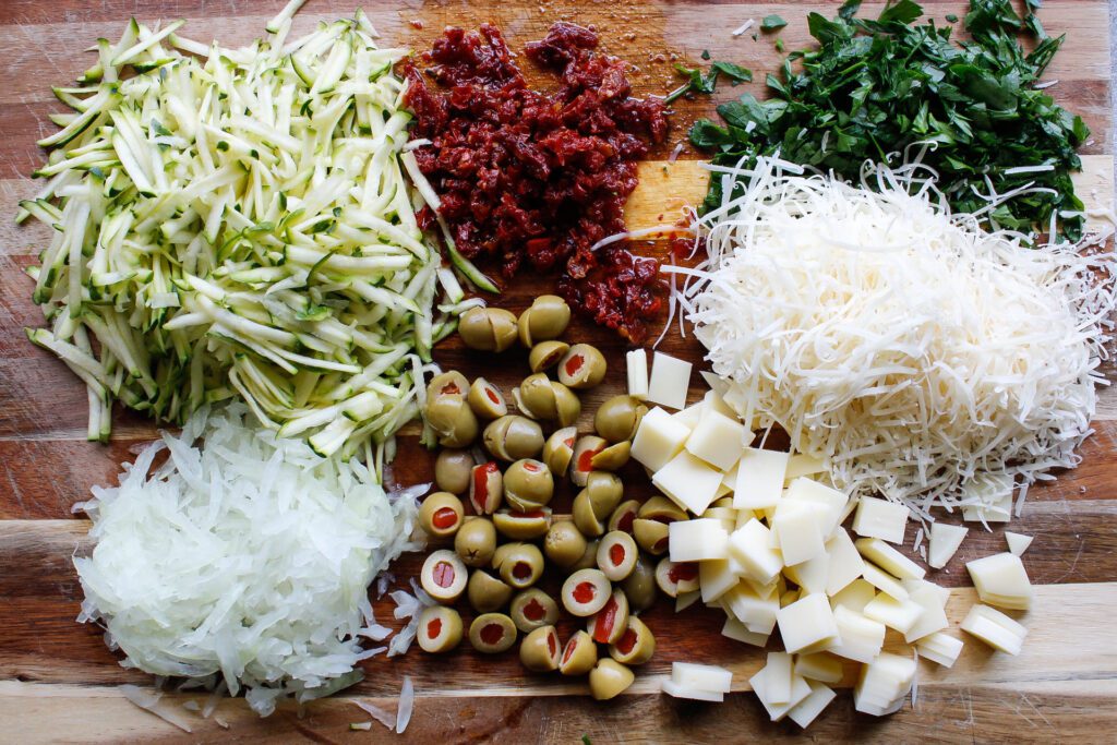ingredients for pasta salad with green olives on a cutting board