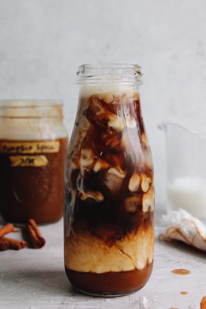 pumpkin spice iced coffee in a glass bottle with milk