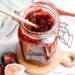 fig jam in a jar on a wooden coaster