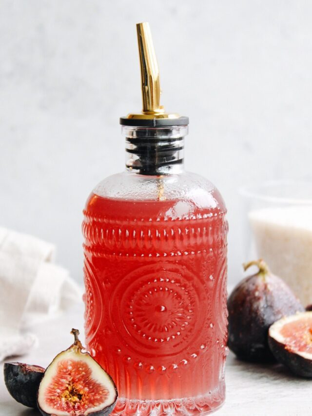 fig syrup in a glass syrup bottle with figs scattered around