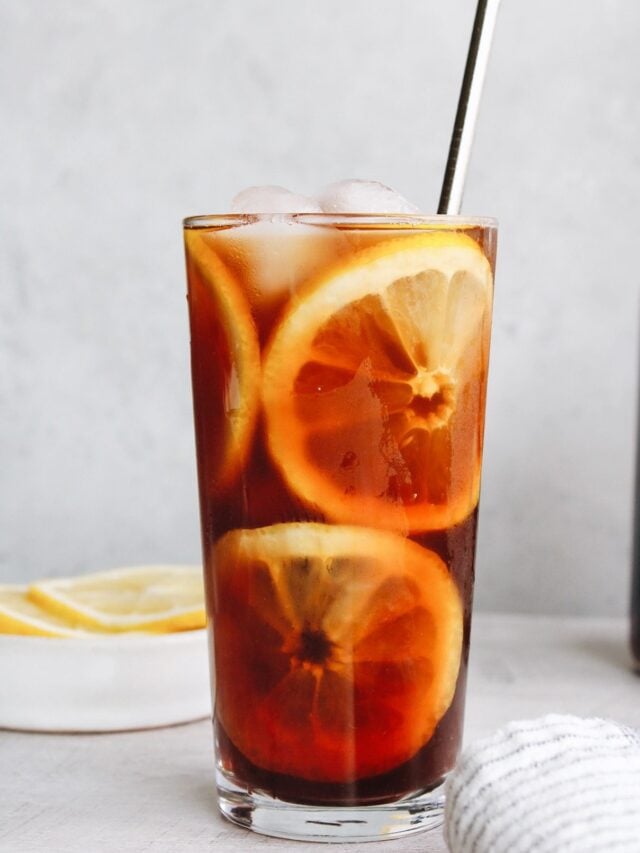 sweet tea with lemon slices in a clear glass and a metal straw