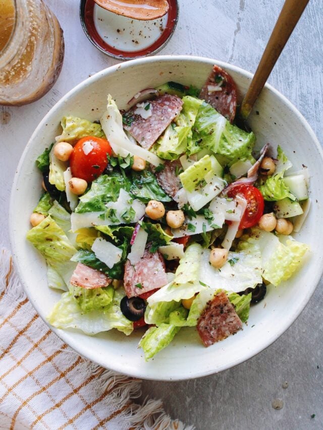 italian chop salad in a white bowl with a plaid napkin on the table