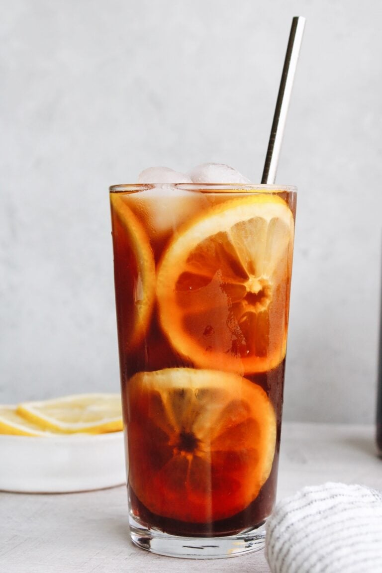 sweet tea with lemon slices in a clear glass and a metal straw