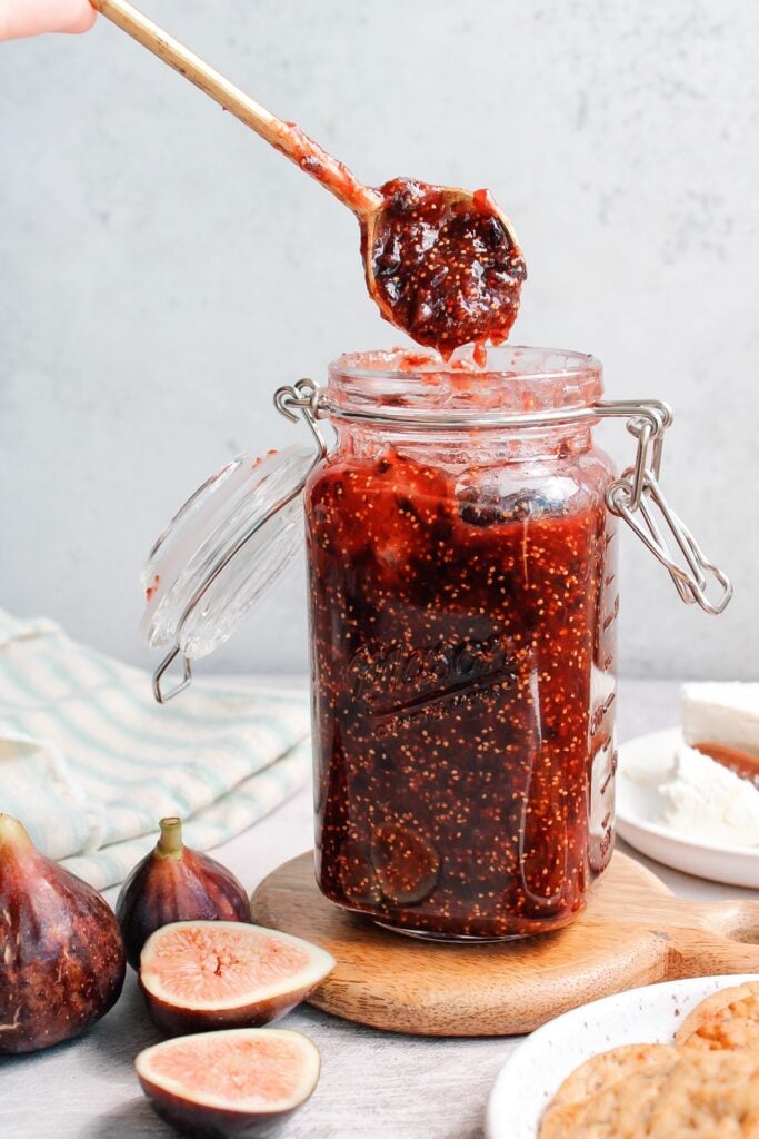 fig jam in a jar with a spoonful of jam being removed from the jar