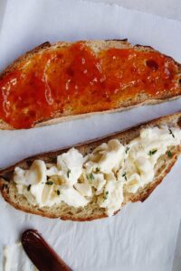 bread with brie cheese on one side and another with apricot jam