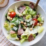 italian chop salad in a white bowl with a plaid napkin on the table