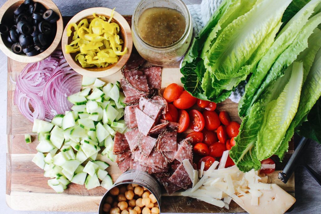 ingredients for italian chop salad on a wooden cutting board