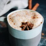 pumpkin chai latte in a striped mug topped with anise