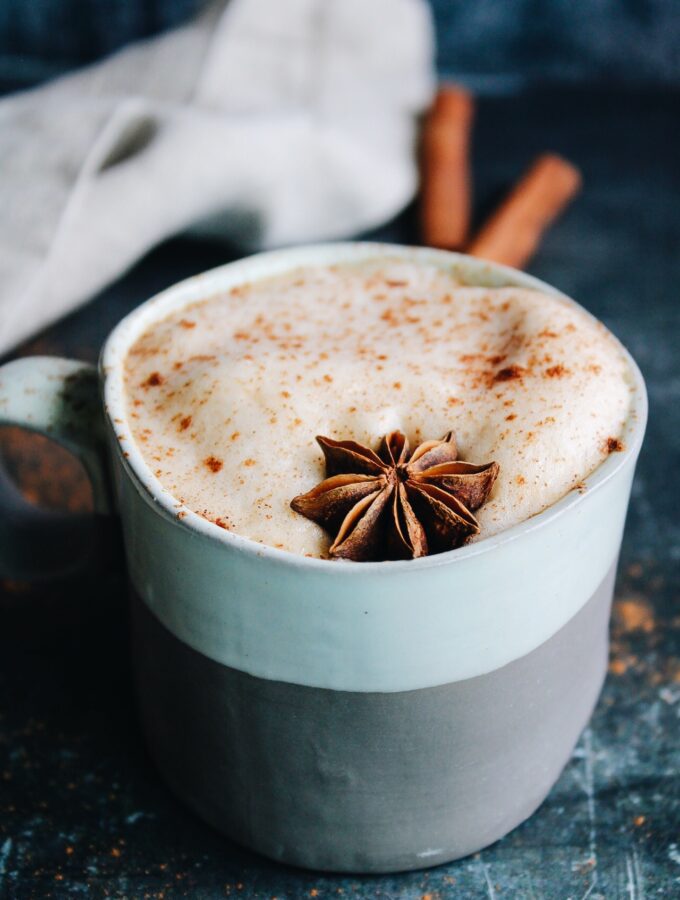 pumpkin chai latte in a striped mug topped with anise