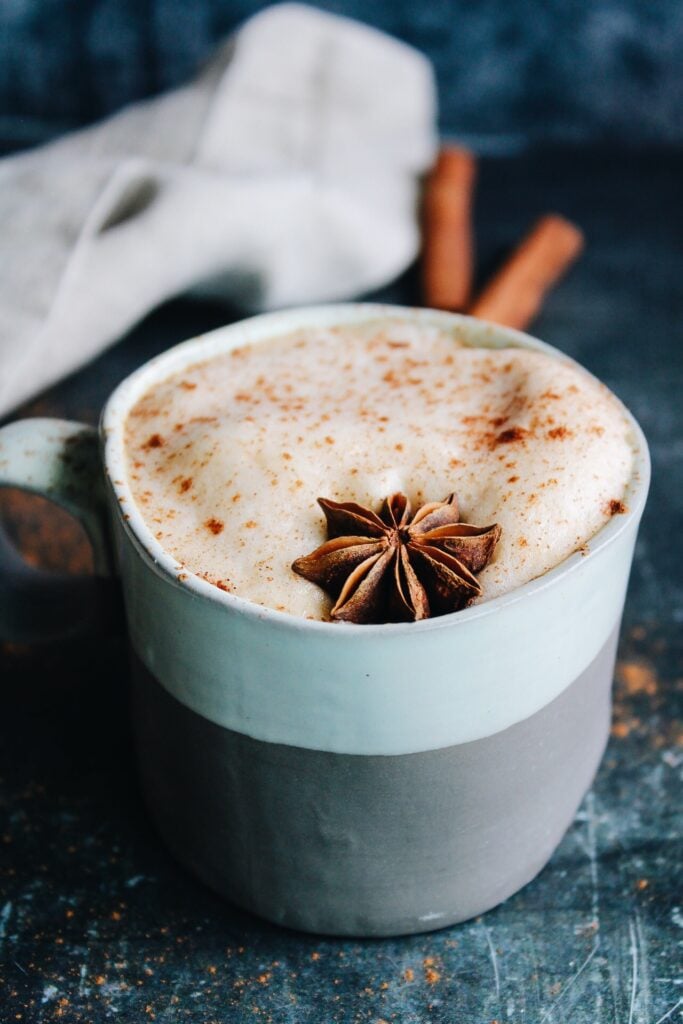 pumpkin chai latte in a striped mug topped with anise