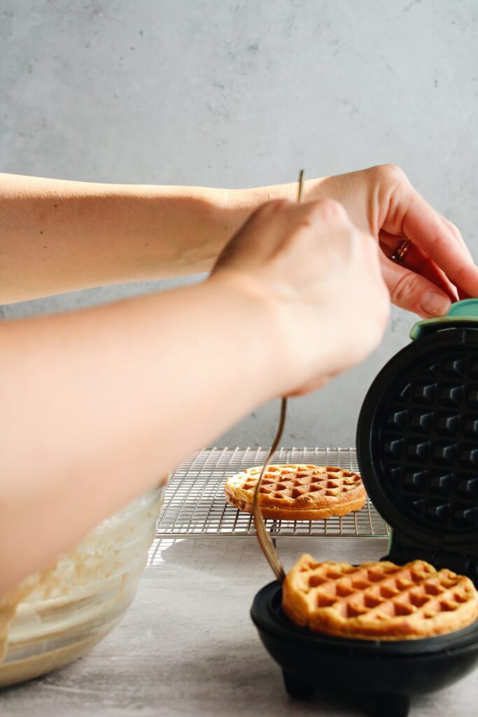 gf pumpkin waffle being removed from waffle iron with a fork