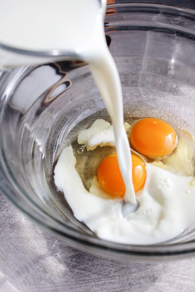 milk and eggs in a clear glass bowl