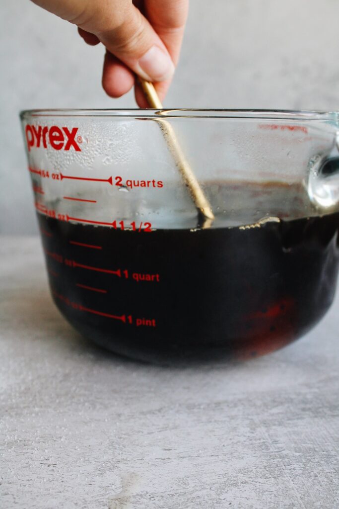 tea, sugar and baking soda being stirred in a large pyrex