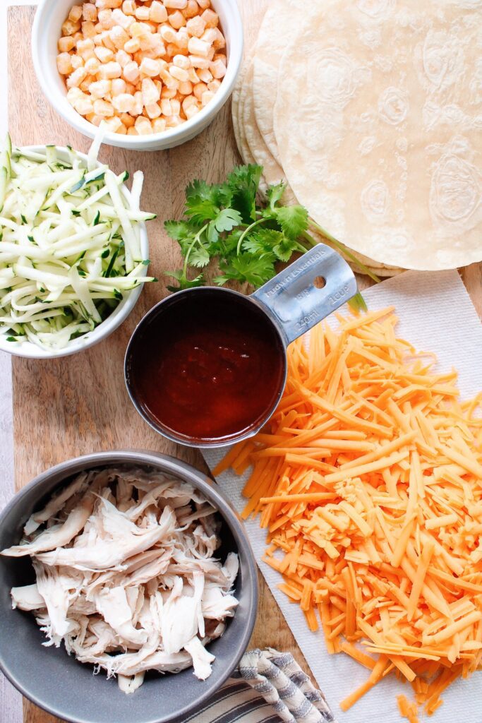 ingredients for bbq chicken quesadillas on a wooden cutting board