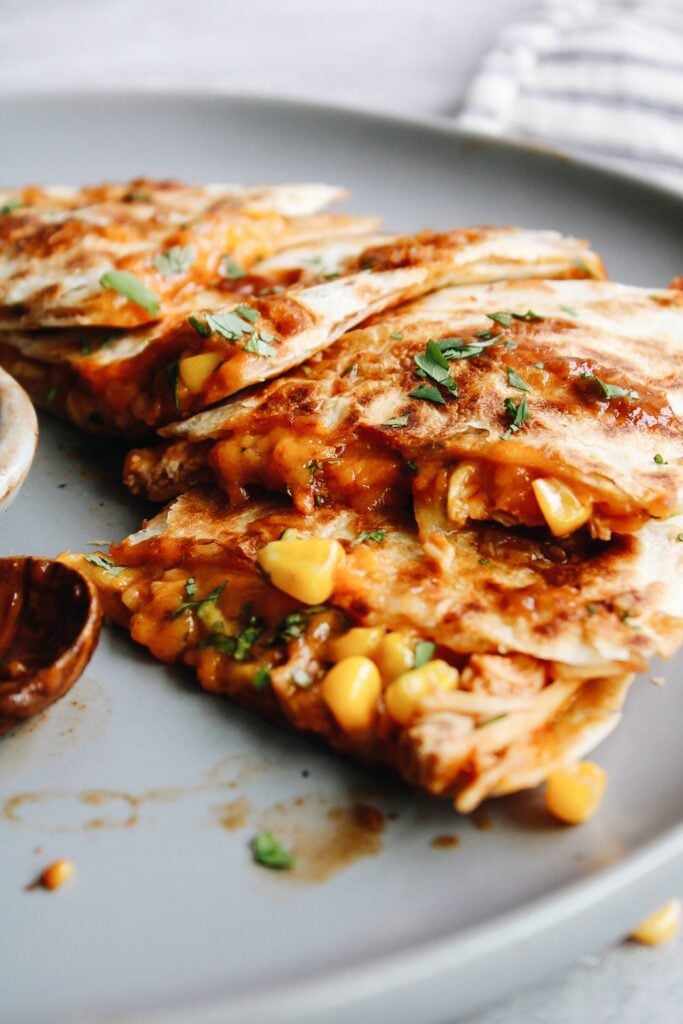 bbq chicken quesadillas on a gray plate with hot sauce