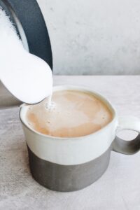 frothed milk being added to chai