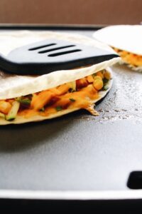 bbq chicken quesadillas cooking on a griddle