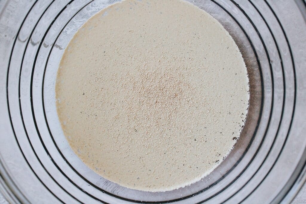 yeast poured on top of warm water in a glass bowl