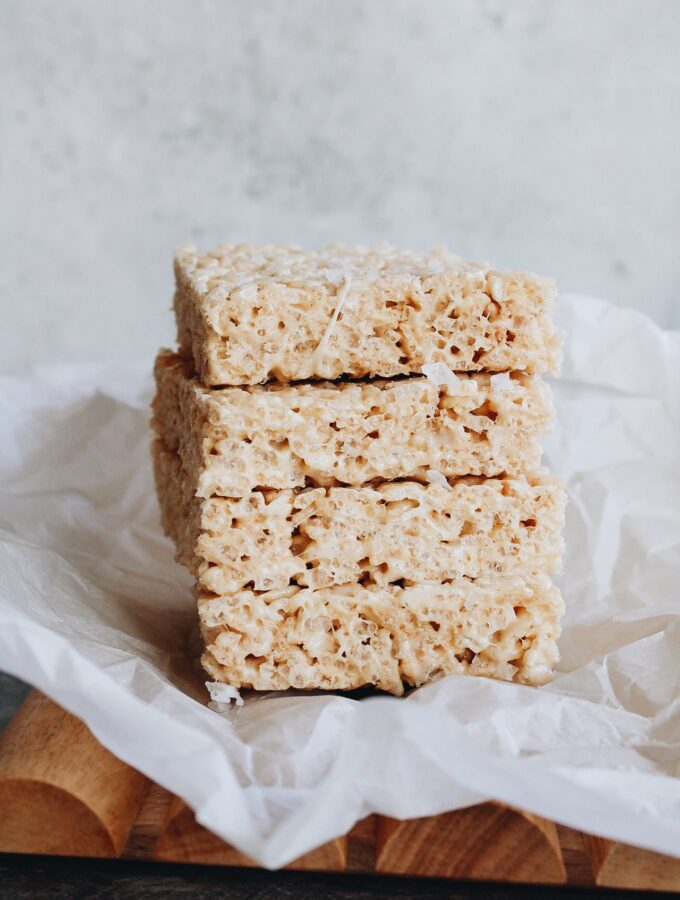 brown butter rice krispie treats stacked on a piece of parchment paper