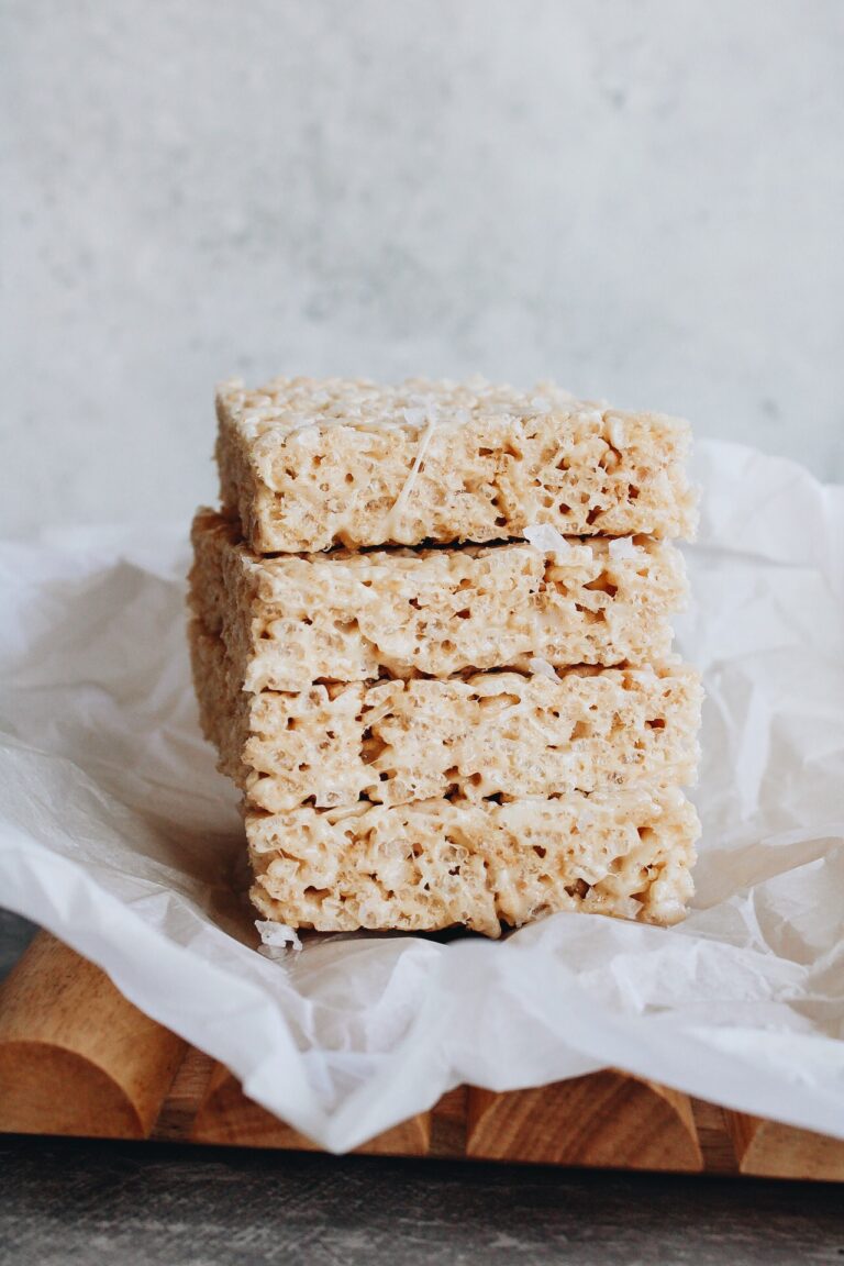 brown butter rice krispie treats stacked on a piece of parchment paper