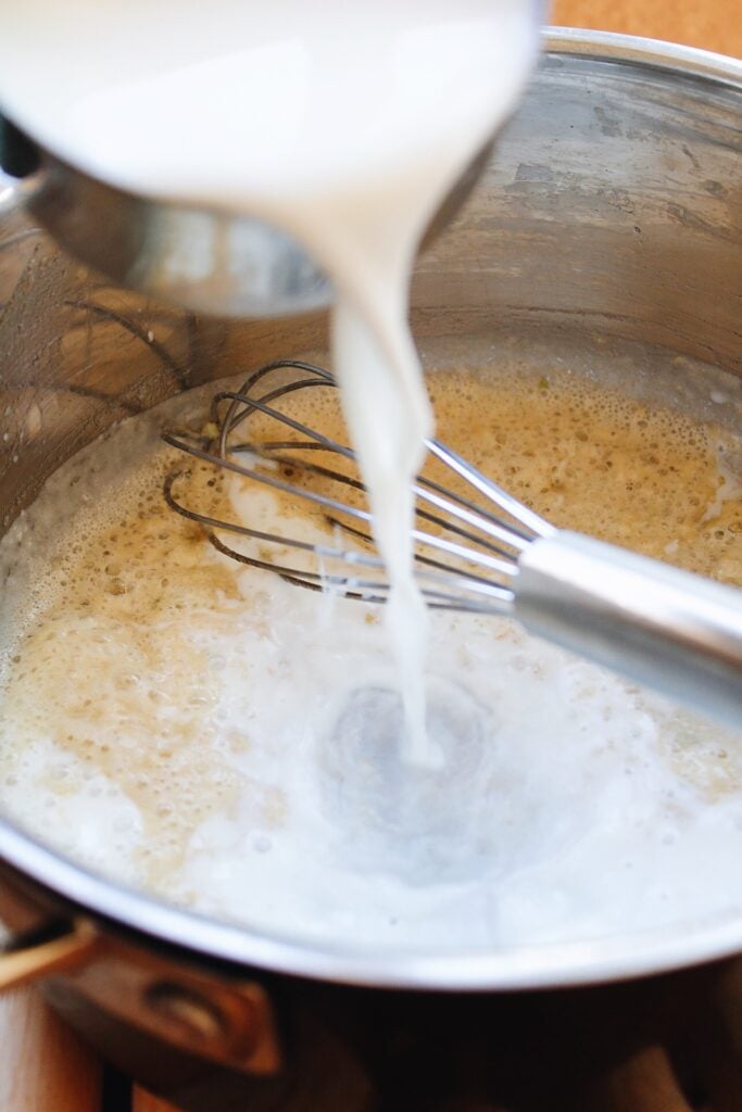 milk added to pot with garlic butter and flour