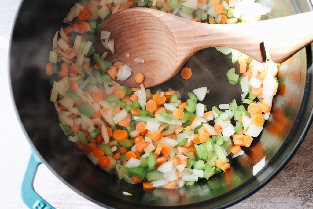 carrot, celery and onion cooking in a dutch oven