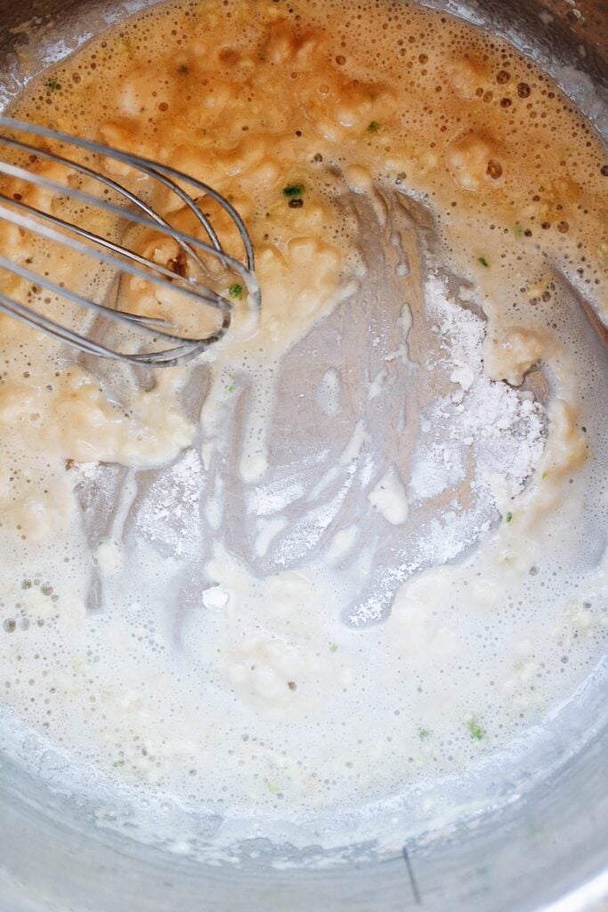 flour being whisked into melted butter and minced garlic