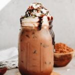 iced peppermint mocha in a jar topped with whipped cream, chocolate syrup and sprinkles